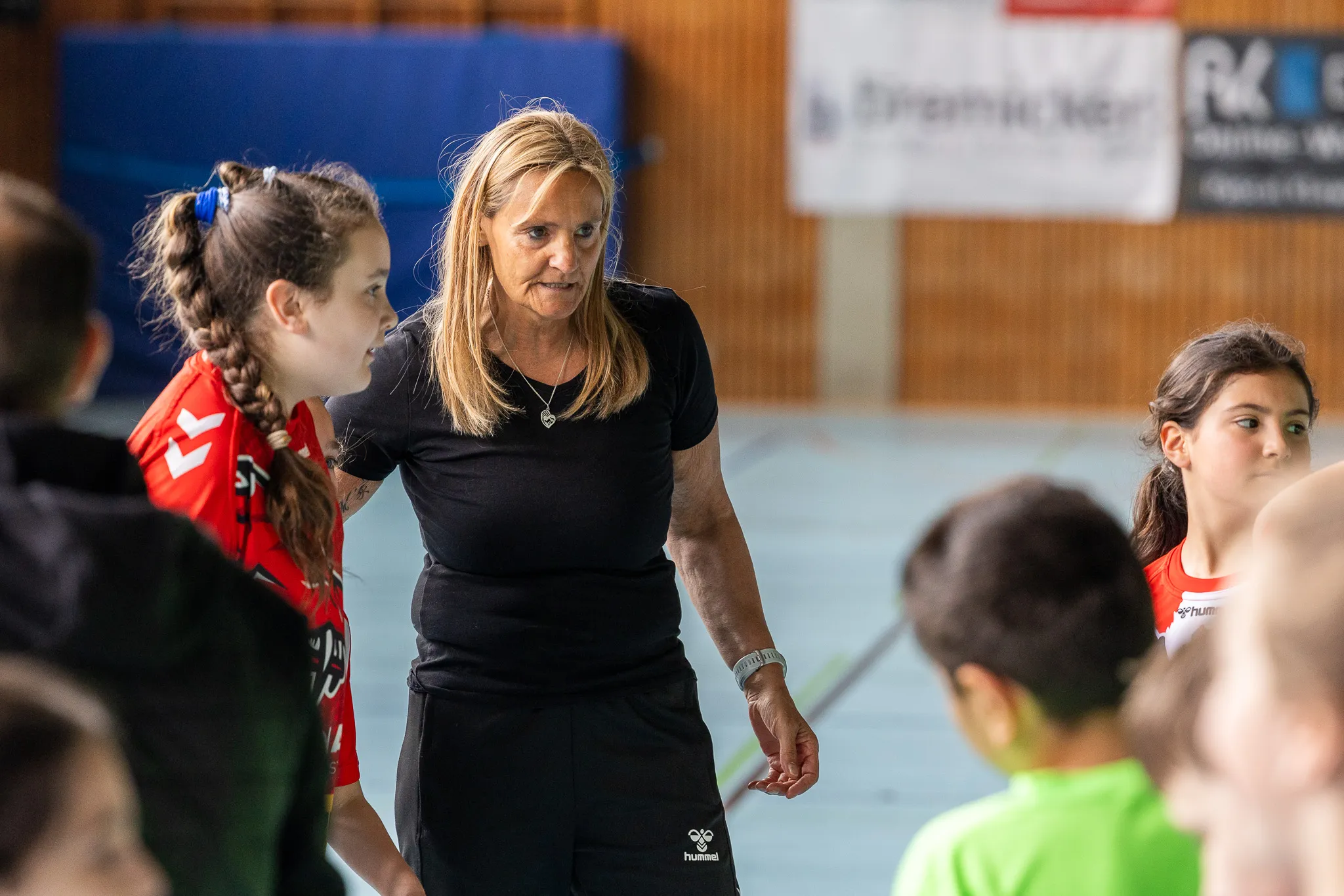 Trainerin erklärt jungen Handballspielerinnen etwas in einer Sporthalle während der Kreismeisterschaften der Grundschulen in Halver.