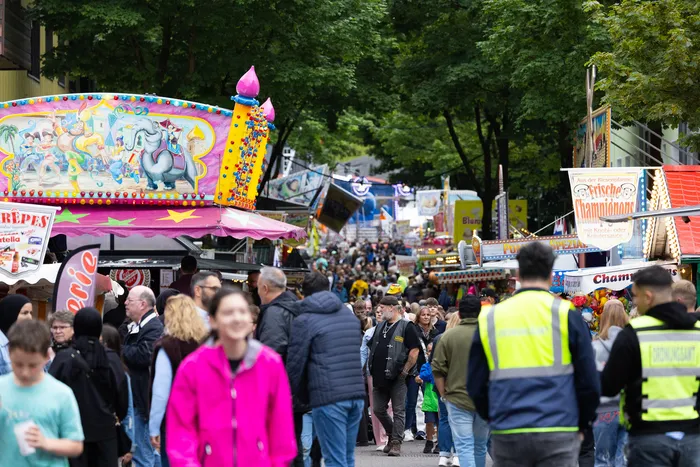Menschenmassen auf der gut besuchten Halveraner Kirmes mit Fahrgeschäften und Imbissständen.