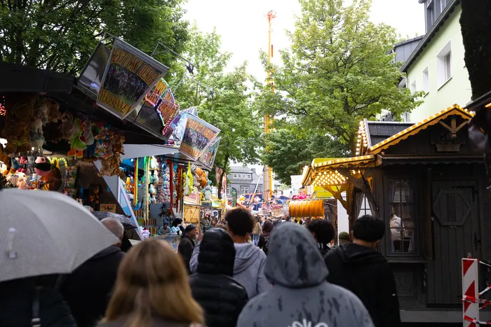 Menschenmengen schlendern auf der gut besuchten Halveraner Kirmes zwischen Spielbuden und Imbissständen.