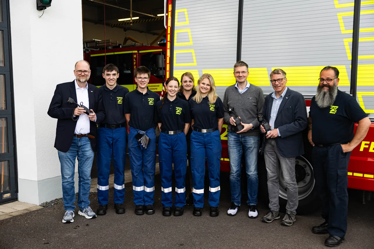 Gruppe von sieben Personen vor einer Feuerwache, darunter Mitglieder der Jugendfeuerwehr Kierspe und Vertreter des Lions Hilfswerkes, die eine Spende erhalten haben.