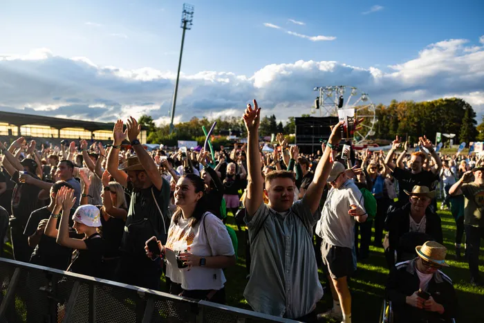 Eine jubelnde Menschenmenge mit erhobenen Händen vor der Main Stage des Bautz-Festivals 2026 und einem Riesenrad im Hintergrund.