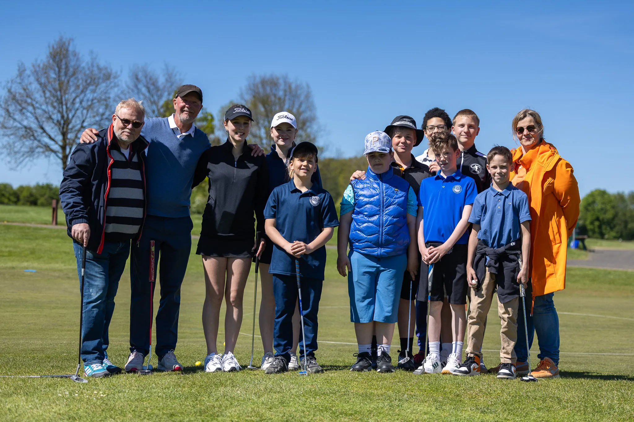 Gruppe von Jugendlichen und Erwachsenen mit Golfschlägern auf einem Golfplatz, vermutlich Mitglieder der neuen Golf-AG des Anne-Frank-Gymnasiums.