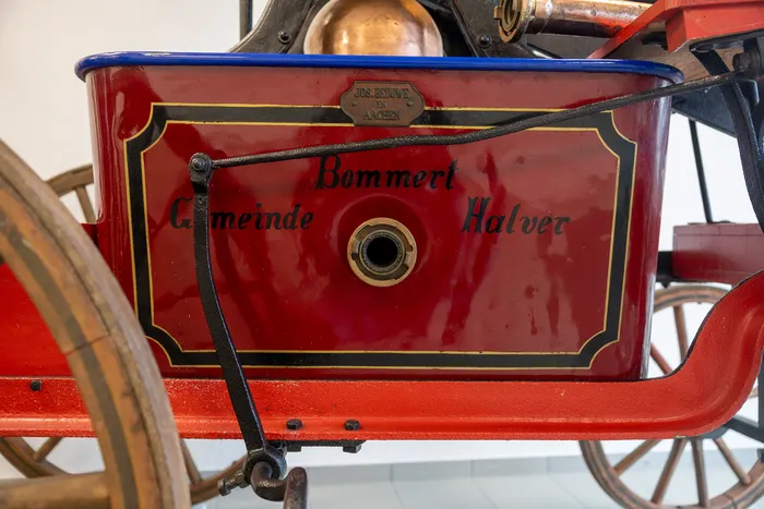 Roter Kasten mit dem Schriftzug „Gemeinde Halver“ und dem Namen „Bommert“ sowie einem Logo von „Jos. Bommert Aachen“. Das ist Teil eines historischen Feuerwehrautos.
