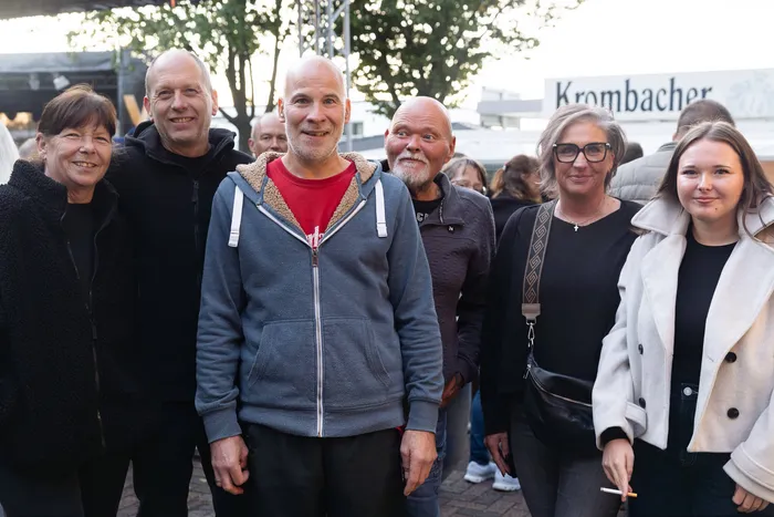 Eine Gruppe lächelnder Menschen posiert bei einem Gemeindefest.