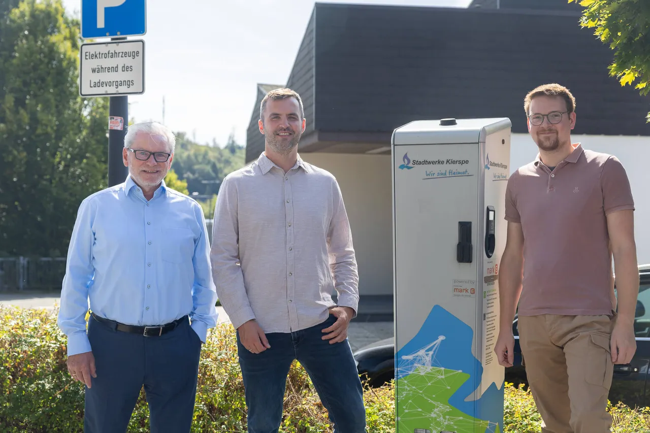 Clemens Wieland, Alexander Plate und Felix Goseberg stehen neben einer E-Auto-Ladestation der Stadtwerke Kierspe.