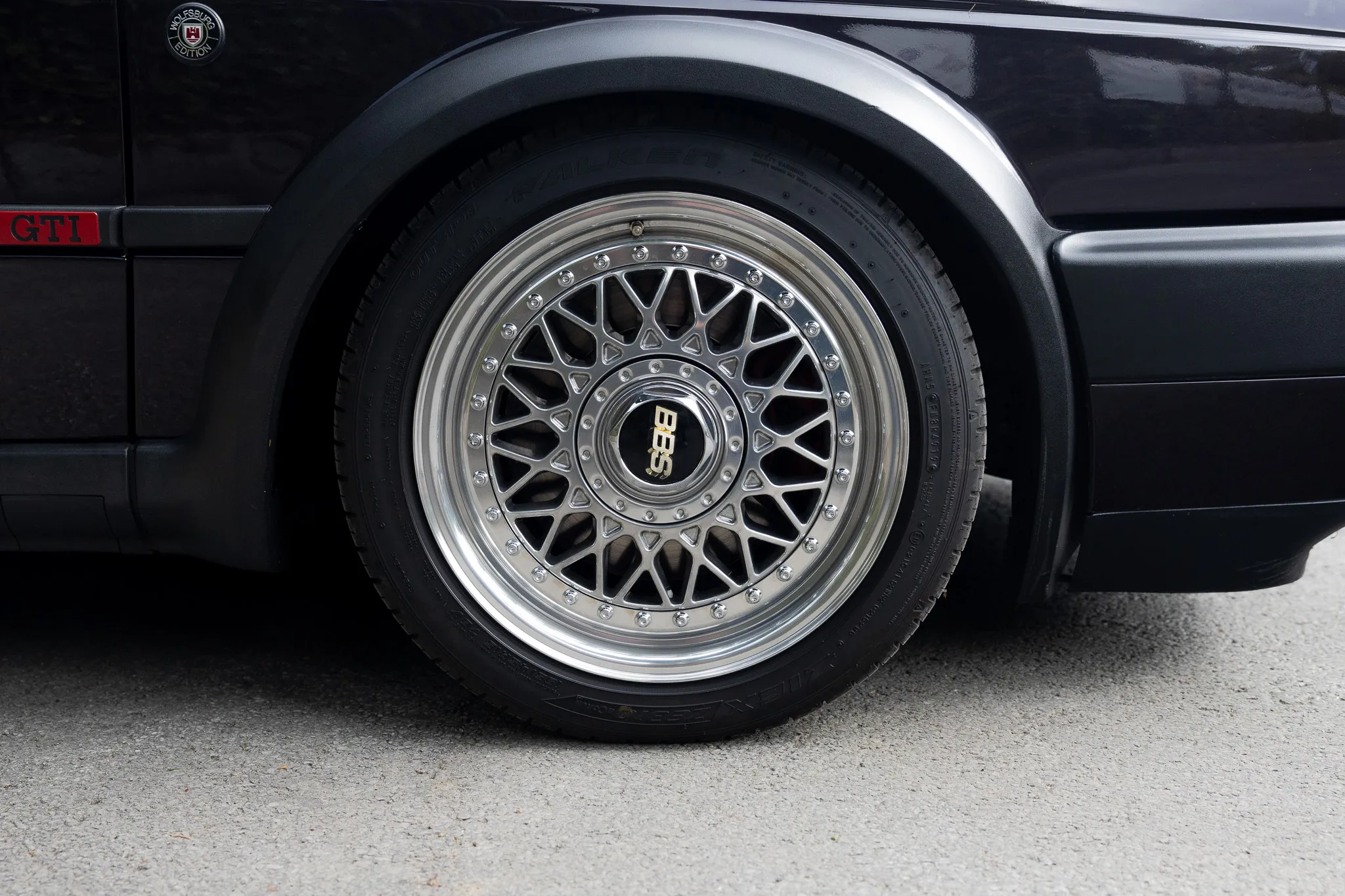 Detailaufnahme des Rades eines schwarzen Oldtimers mit silberner Felge und dem BBS-Logo.