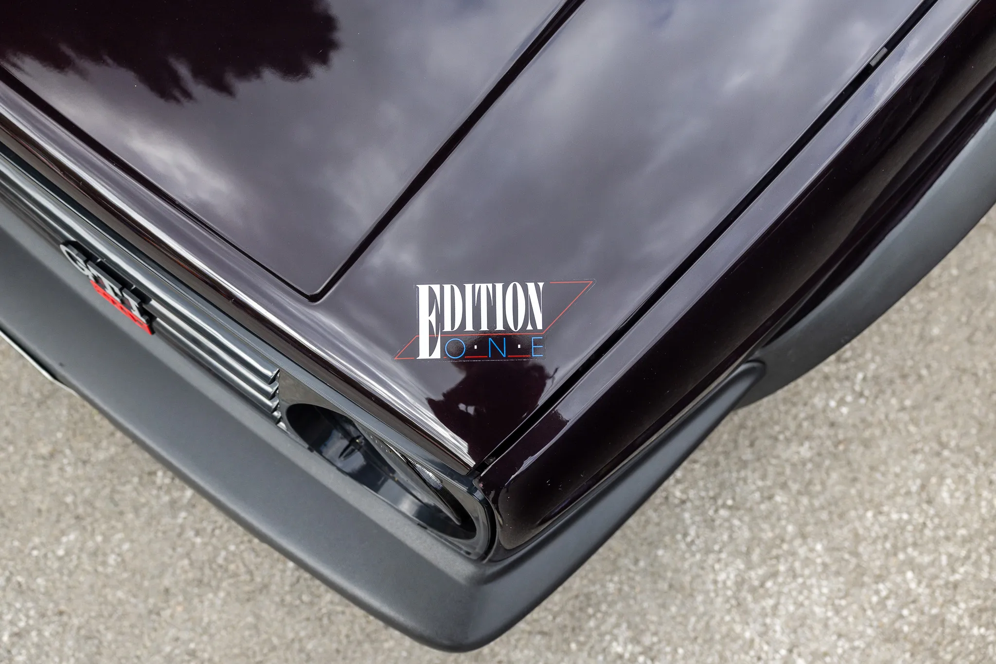 Dunkelroter Oldtimer mit dem Schriftzug „EDITION ONE“ auf der Motorhaube.