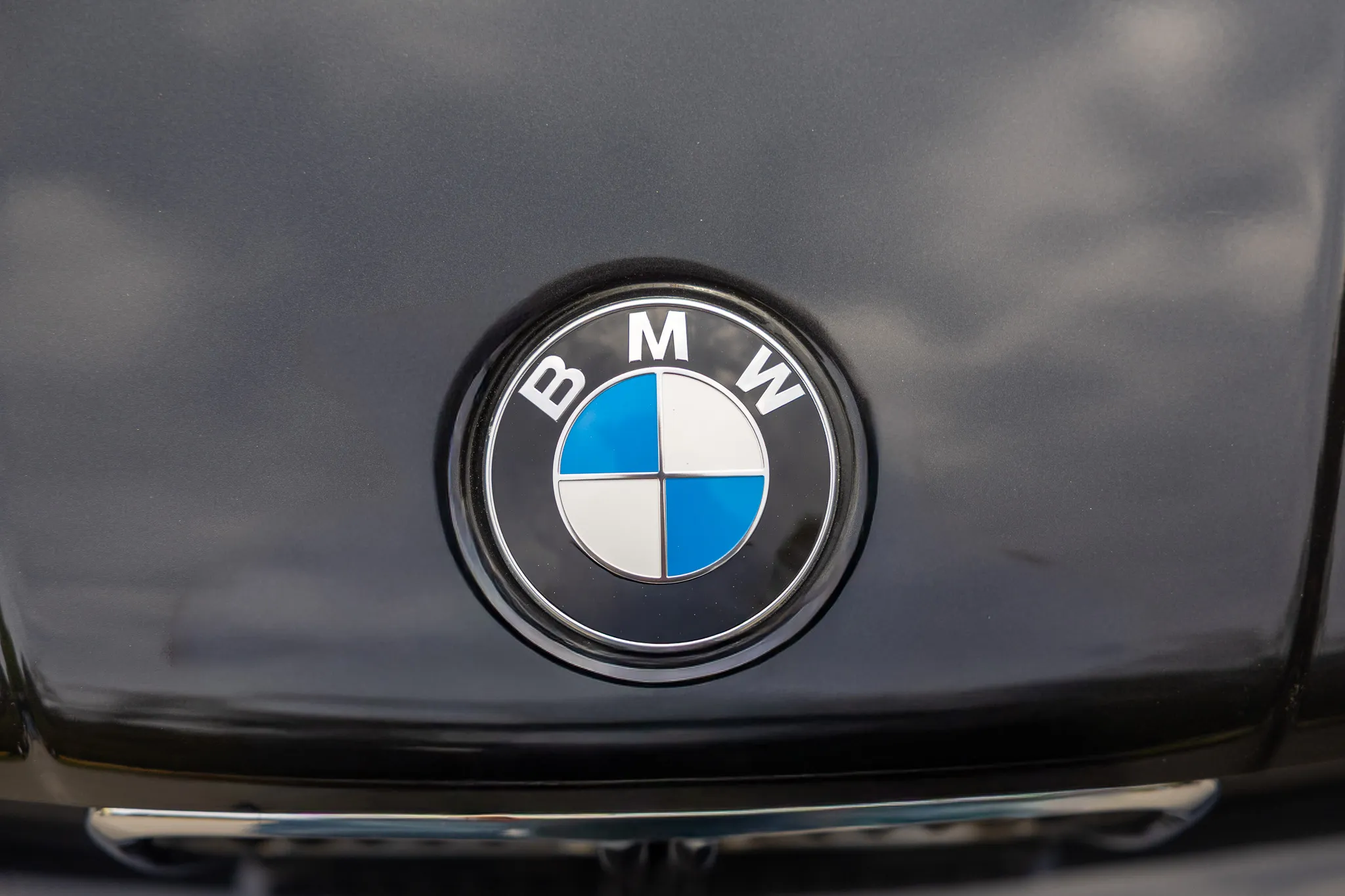 Nahaufnahme des BMW-Logos auf der Motorhaube eines Autos.