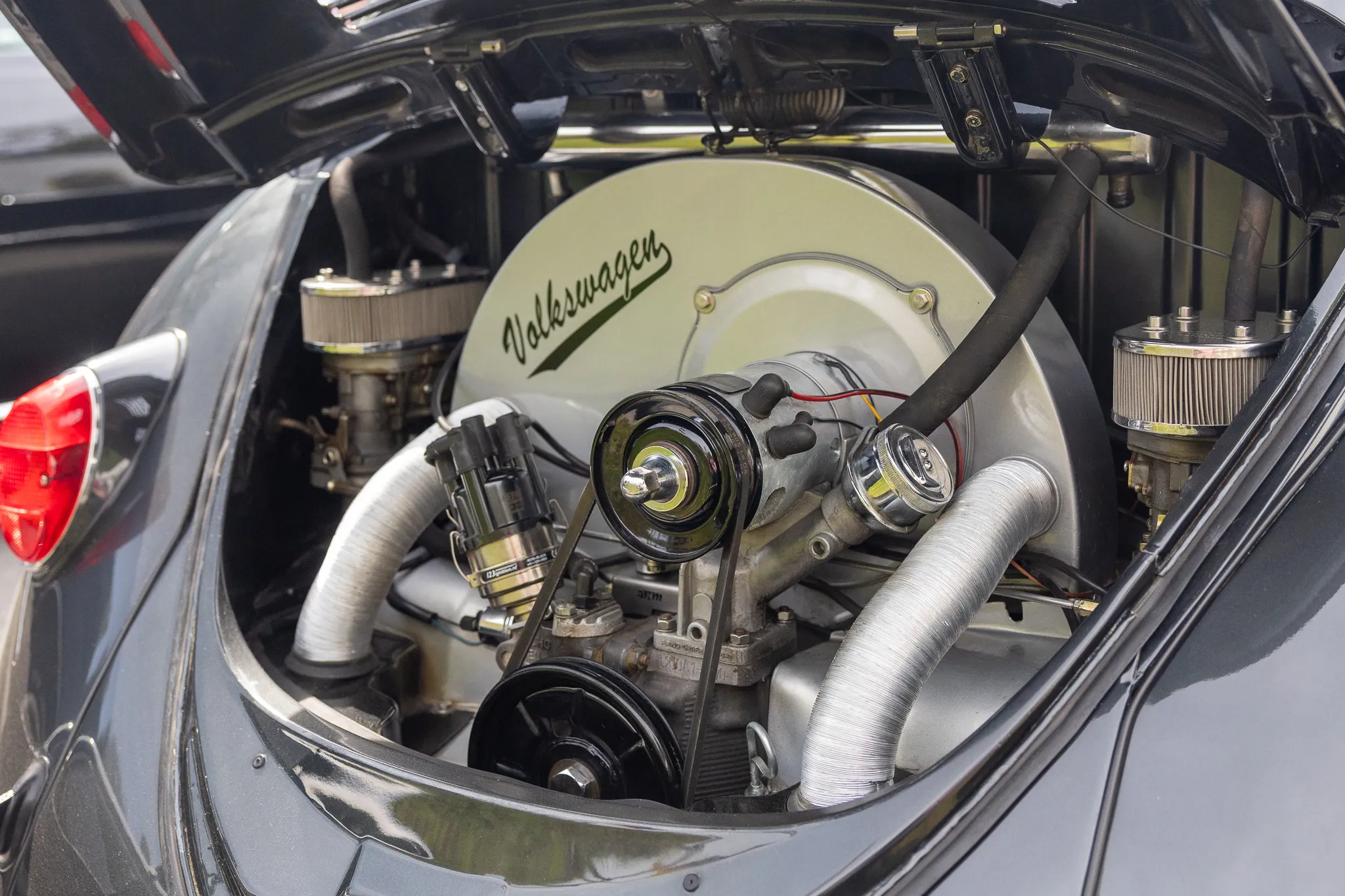 Motorraum eines klassischen Volkswagen Käfers, der das Logo „Volkswagen“ trägt.