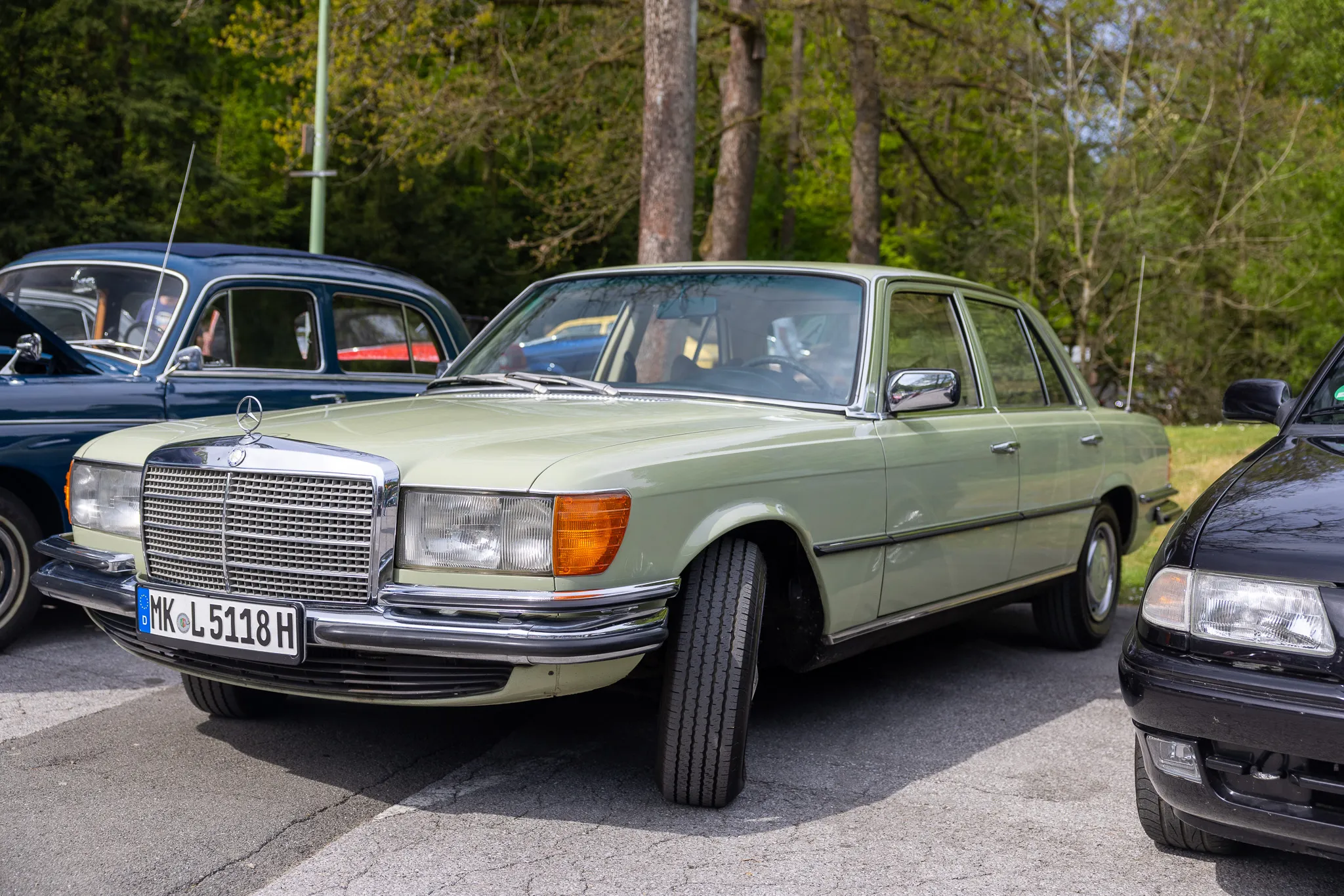 Hellgrüne Mercedes-Benz S-Klasse (W116) mit Kennzeichen MK-L 5118 H steht vor anderen Oldtimern auf einem Parkplatz.