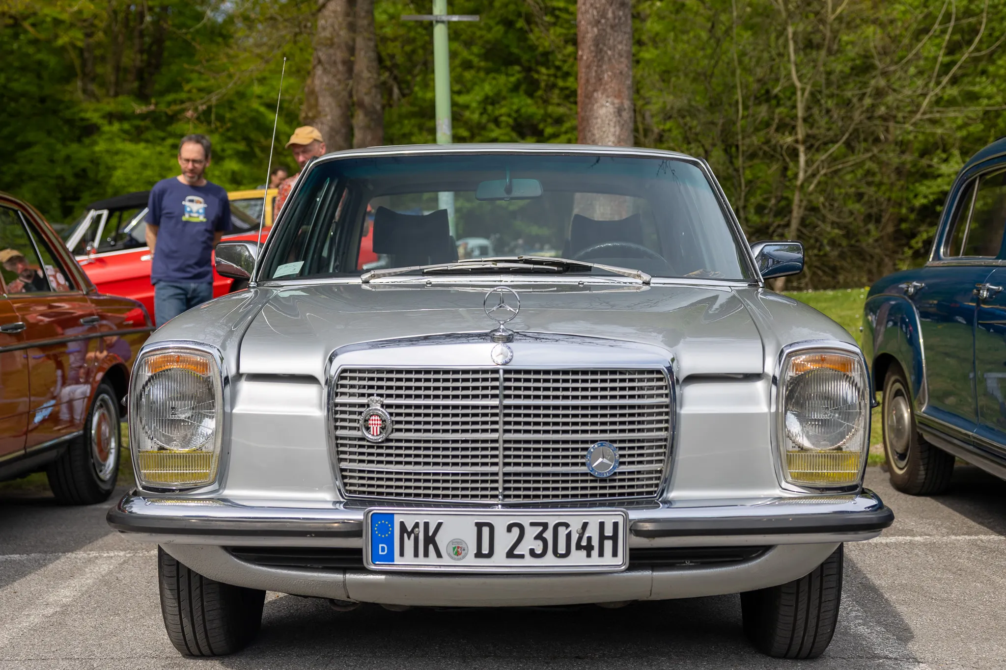 Silberfarbener Mercedes-Benz W 116 mit Kennzeichen MK-D 2304H steht im Mittelpunkt eines Oldtimertreffens.