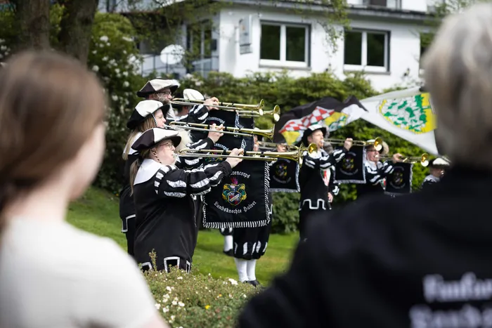 Musikzug der Freiwilligen Feuerwehr Halver spielt während der Saisoneröffnung auf. Die Musiker tragen schwarze Uniformen mit gelben Akzenten und spielen Posaunen und andere Blechblasinstrumente.