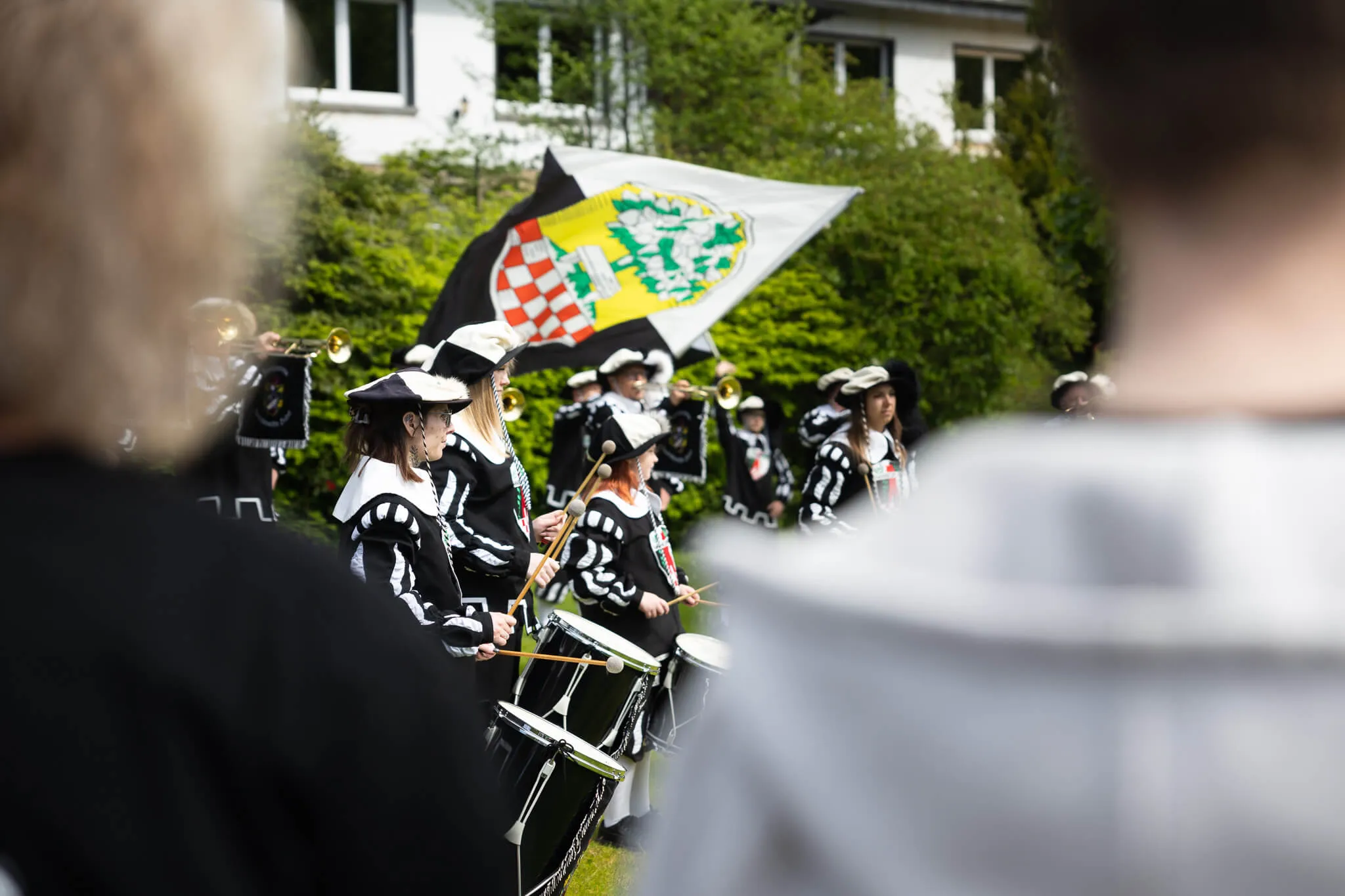 Musikzug der Freiwilligen Feuerwehr Halver spielt bei der Saisoneröffnung auf, im Hintergrund eine Fahne mit Wappen.