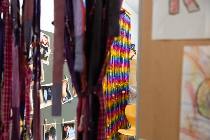 Bunte Folienvorhänge und Fotos von Schülerinnen und Schülern schmücken einen Flur an der Schule an der Höh zum 50-jährigen Jubiläum.
