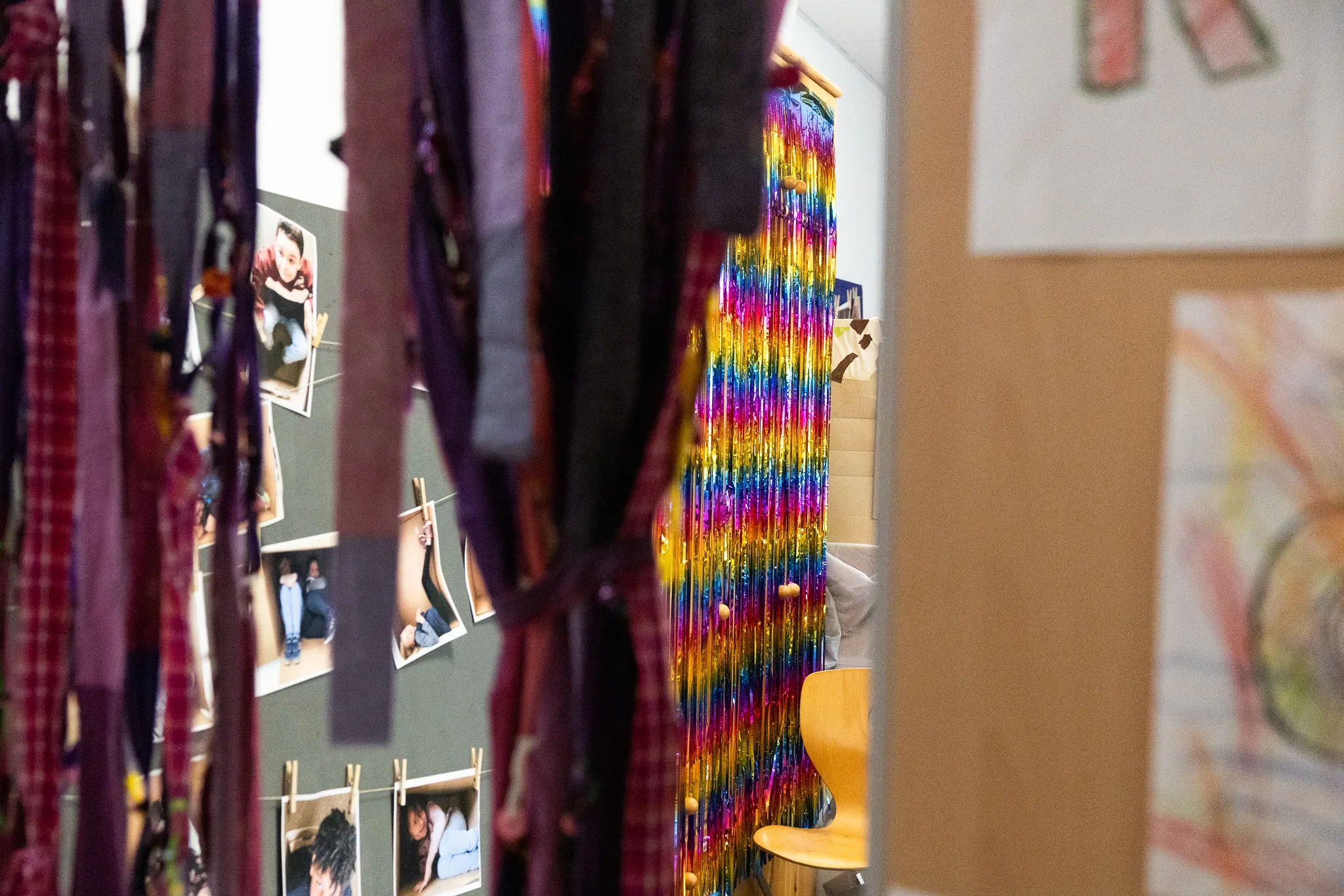 Bunte Folienvorhänge und Fotos von Schülerinnen und Schülern schmücken einen Flur an der Schule an der Höh zum 50-jährigen Jubiläum.