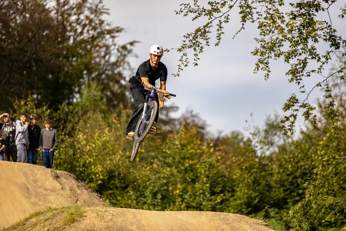 Ein Radfahrer springt mit seinem Mountainbike über eine Dirt-Jump-Anlage im Bikepark Halver.