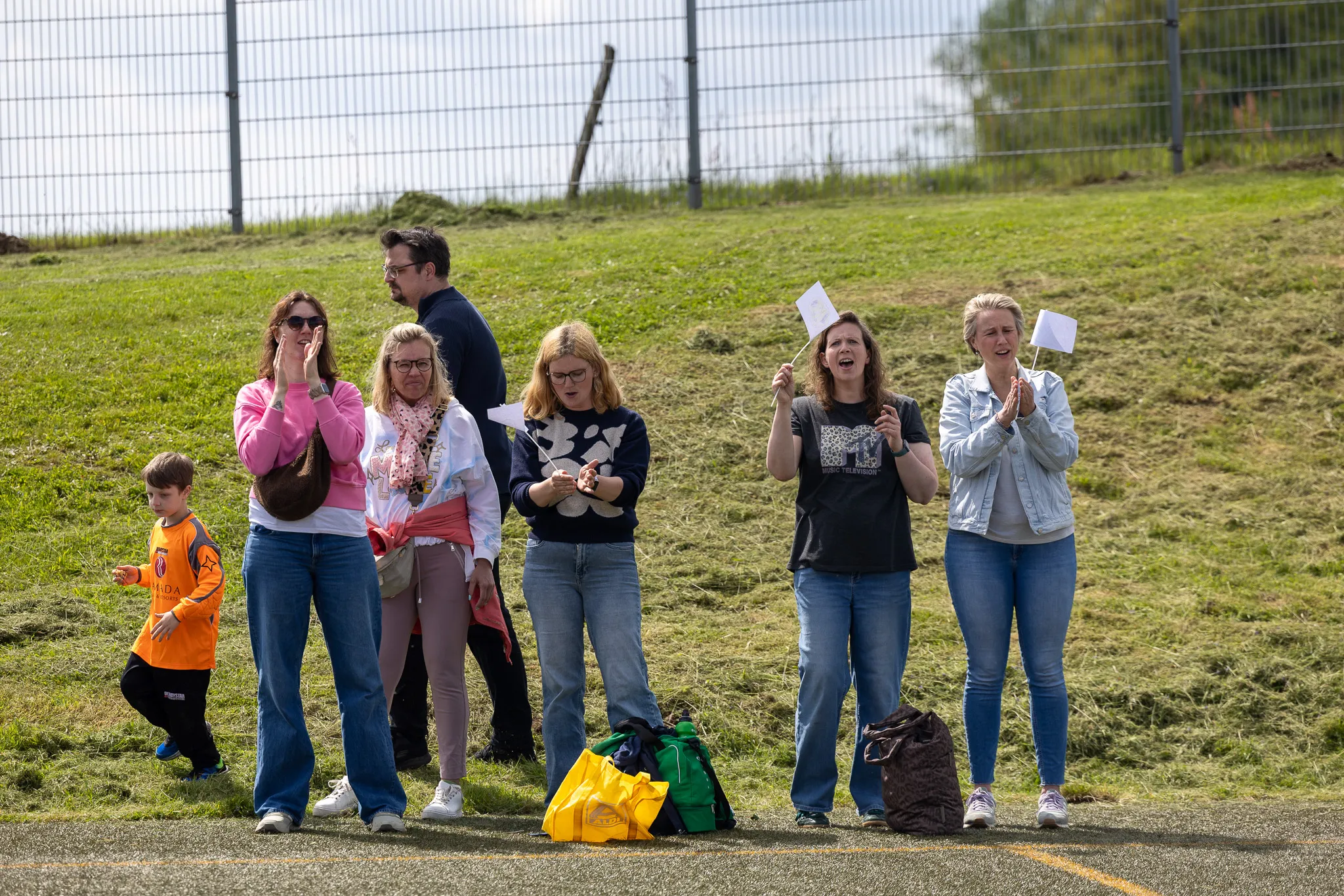 Eine Gruppe von Zuschauern, darunter auch Kinder, jubelt und klatscht bei einem Fußballturnier am Kreisch.