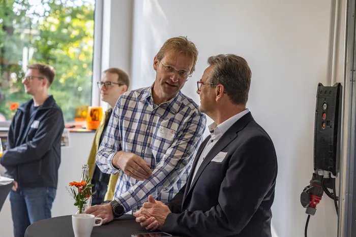 Zwei Männer im Gespräch bei der Jubiläumsfeier des Unternehmens Janßen&Janßen.