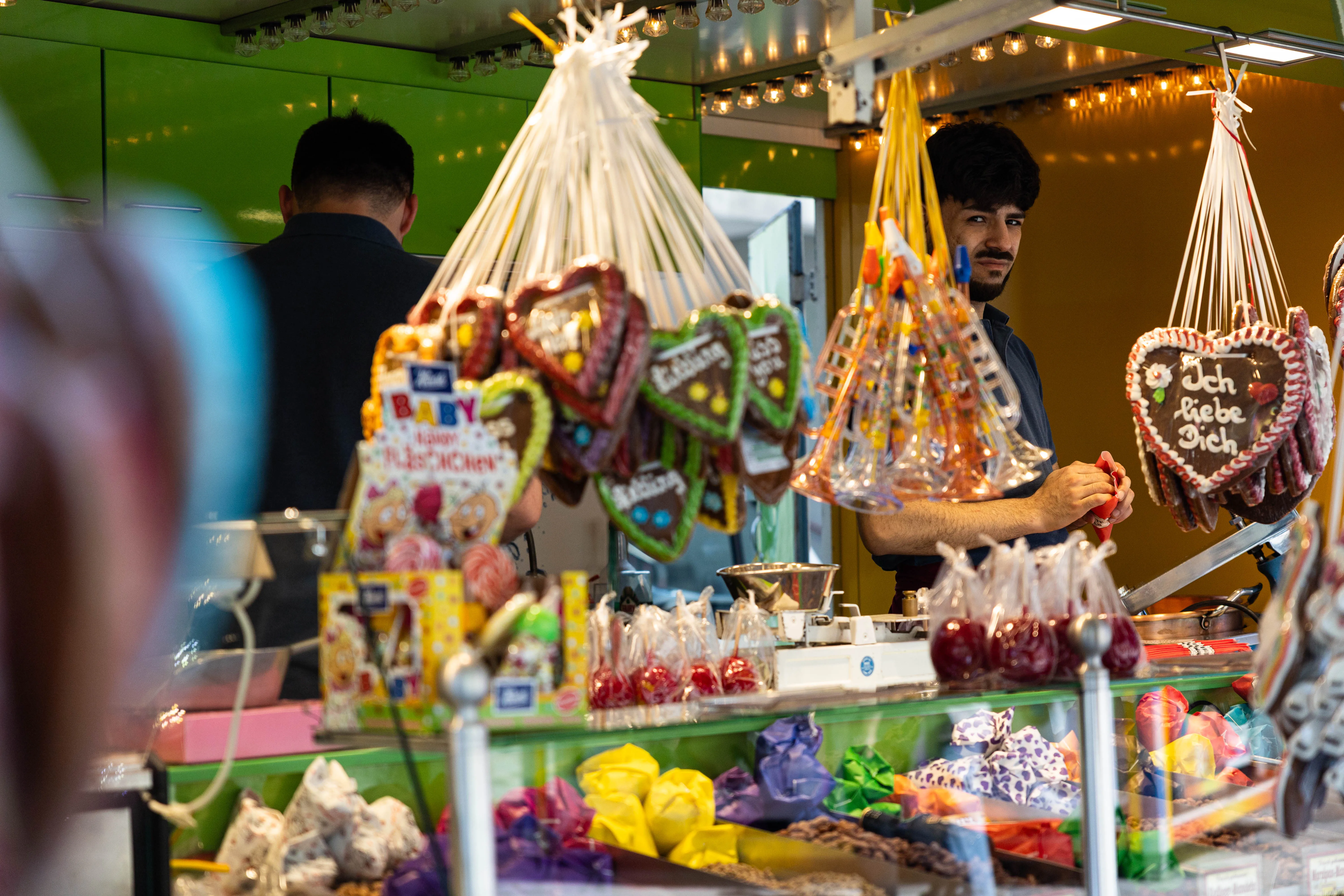 Verkäufer an einem Stand mit Lebkuchenherzen und Süßigkeiten auf der Meinerzhagener Pfingskirmes.
