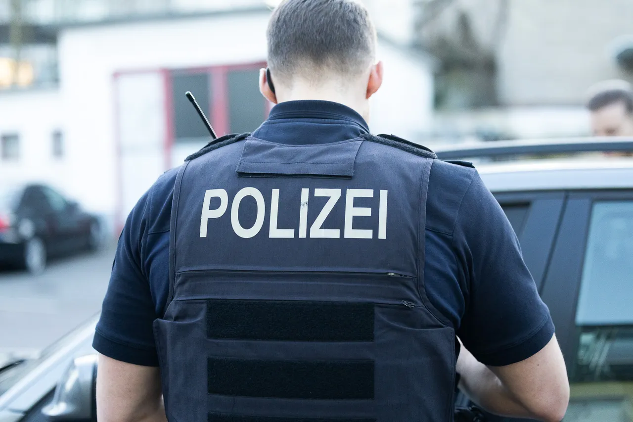 Rückansicht einer Person mit der Aufschrift „POLIZEI“ auf der Schutzweste, vermutlich ein Polizist im Einsatz.