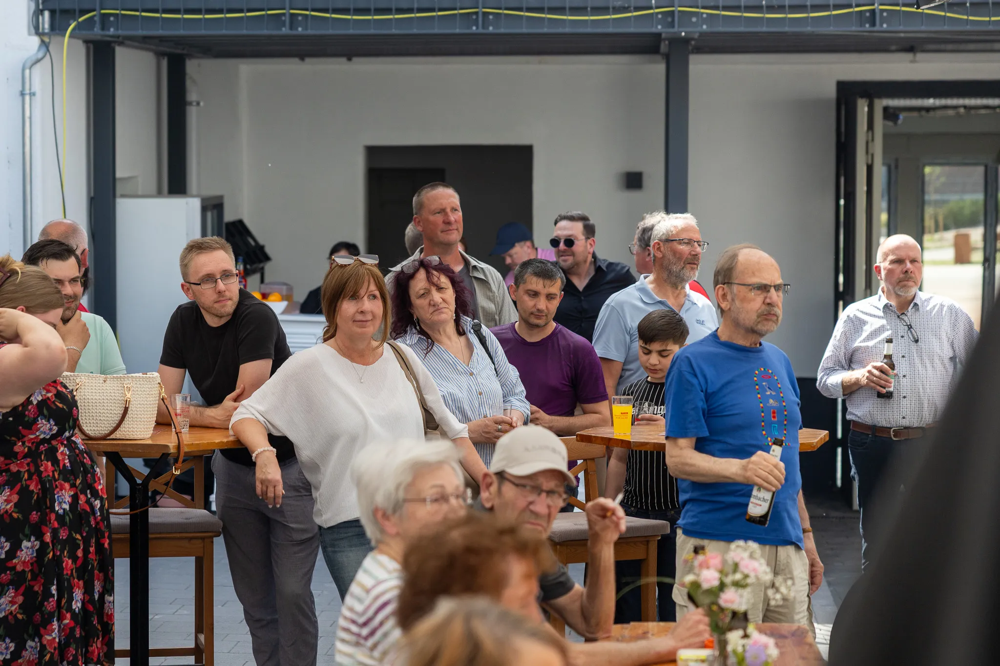 Menschen stehen und unterhalten sich vor einem modernen Gebäude während der Eröffnungsfeier des Kreativ.Quartier.Wippermann.