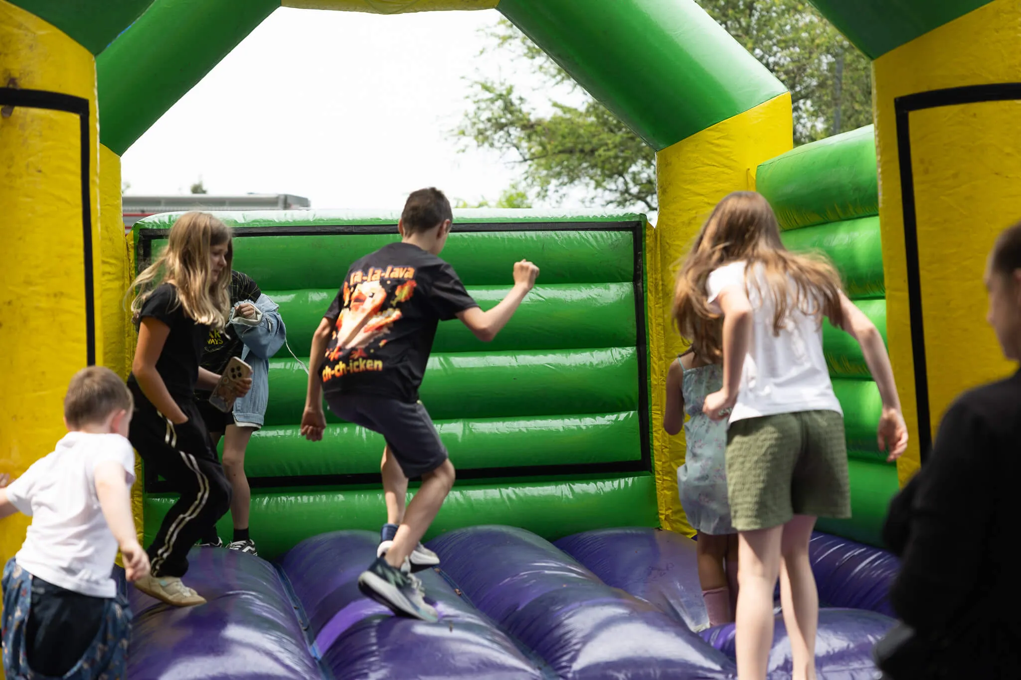 Kinder springen und laufen auf einer aufblasbaren Hüpfburg auf dem Schulfest der Humboldtschule.