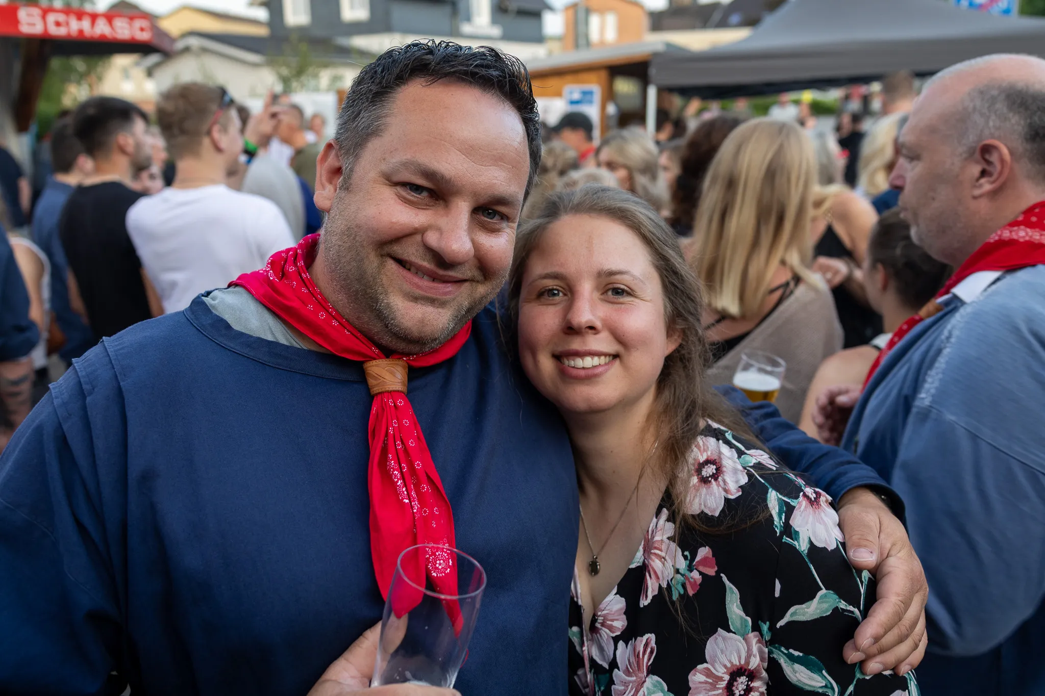 Lachendes Paar umarmt sich vor einer Menschenmenge auf dem Marktplatz während des Königsballs der Bauernschützen.
