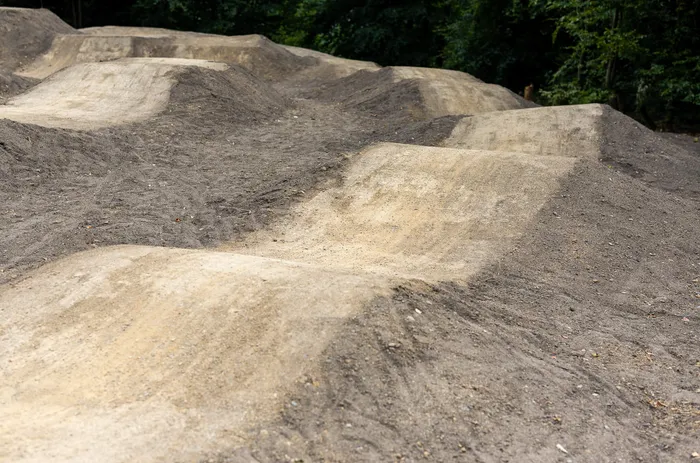 Verschiedene Erdhügel und Sprungrampen in einem Bikepark.
