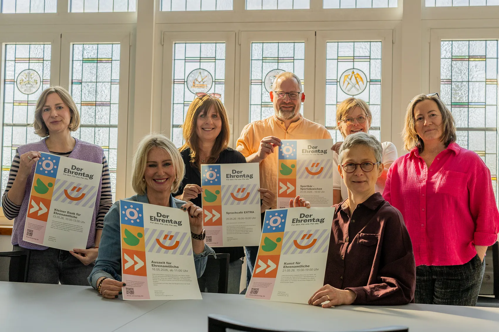 Sieben Personen halten Flyer für Veranstaltungen zum Ehrenamt in Halver hoch, darunter die Bürgermeisterin und Vertreter von Stadtbücherei, Bürgerzentrum, Sprachcafé, Stadtsportverband und Villa Wippermann.