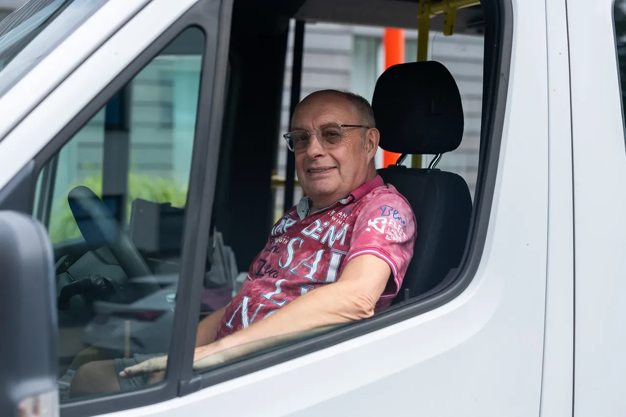 Peter Baumgart sitzt am Steuer eines weißen Transporters und blickt in die Kamera.