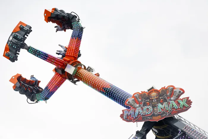 Der Fahrgeschäft „Mad Max“ auf der Kirmes mit rot-blau gepunkteten Armen und einem Totenkopf-Logo.
