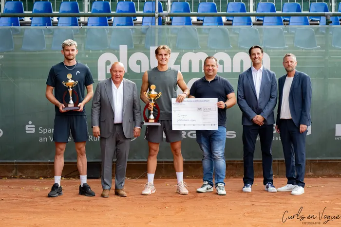 Siegerehrung der Platzmann Open 2026 mit zwei Männern, die Trophäen halten, und einem Mann, der einen großen Scheck präsentiert.