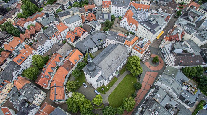 Luftaufnahme der historischen Altstadt von Lüdenscheid mit dicht gedachten Fachwerkhäusern und einer Kirche mit angrenzendem Park.