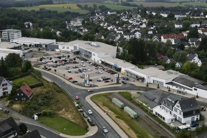 Luftaufnahme des Fachmarktzentrums in Halver mit Parkplätzen, Einzelhandelsgebäuden und umliegenden Wohngebieten.
