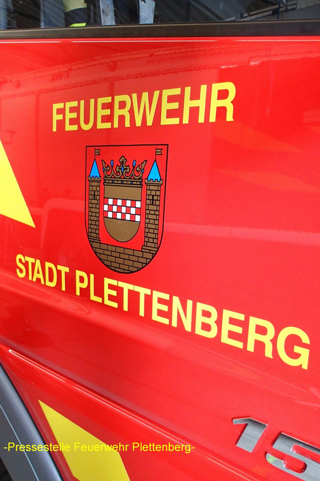Rotes Fahrzeug der Feuerwehr Plettenberg mit Wappen und Aufschrift.