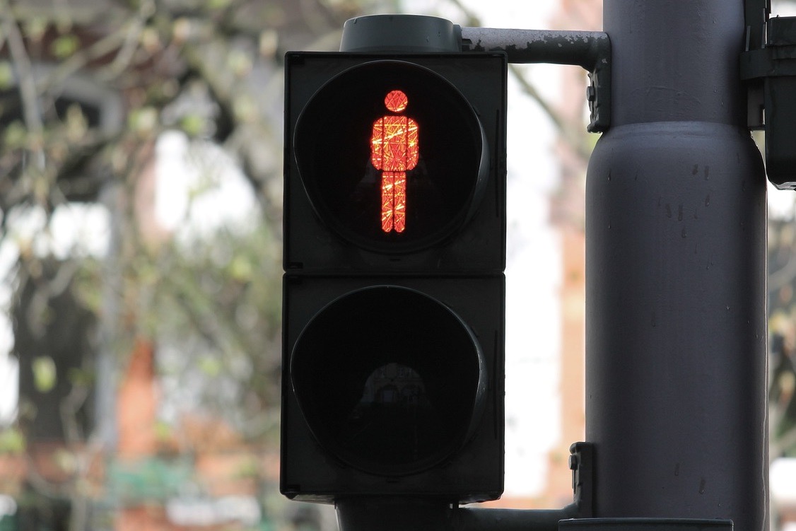 Fußgängerampel zeigt rotes Licht mit einem roten Strichmännchen.
