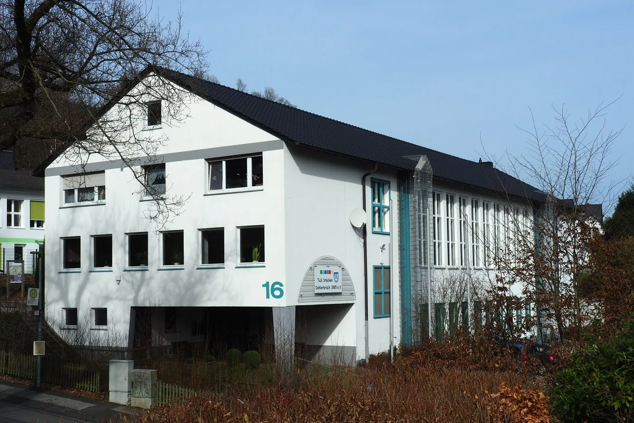 Zweistöckiges Wohnhaus mit dunklem Dach und hellen Fassaden, Hausnummer 16 gut sichtbar. Ein Schild am Haus weist auf ‚Dr. Stücken‘ und ‚Zahnärztliche Praxis‘ hin.