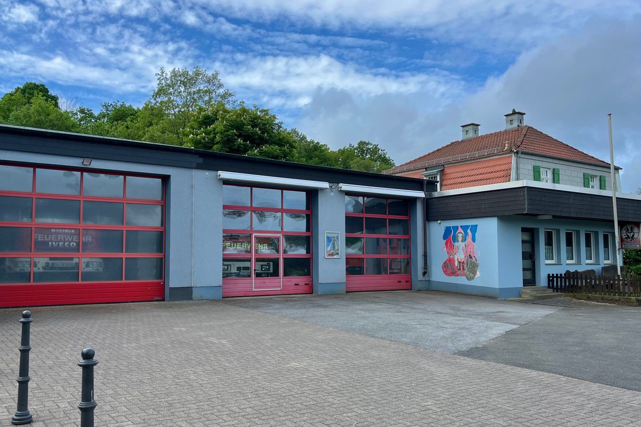 Das Gerätehaus der Feuerwehr Löschgruppe Zurstraße in Breckerfeld mit drei großen roten Garagentoren und einem Wandgemälde an der Fassade.