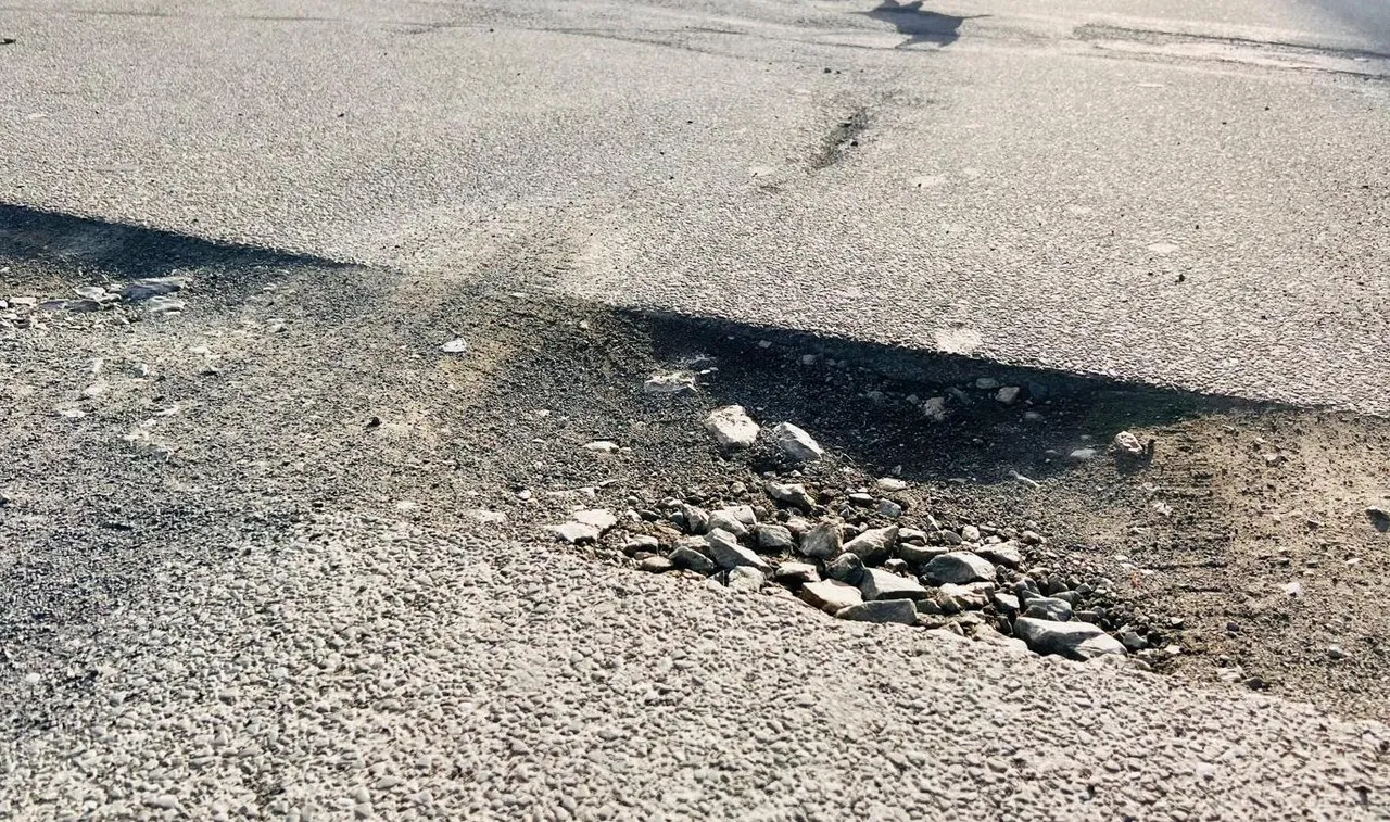 Ein großes Schlagloch im Asphalt der Kantstraße in Halver, vermutlich entstanden durch die Bauarbeiten für den Glasfaserausbau.