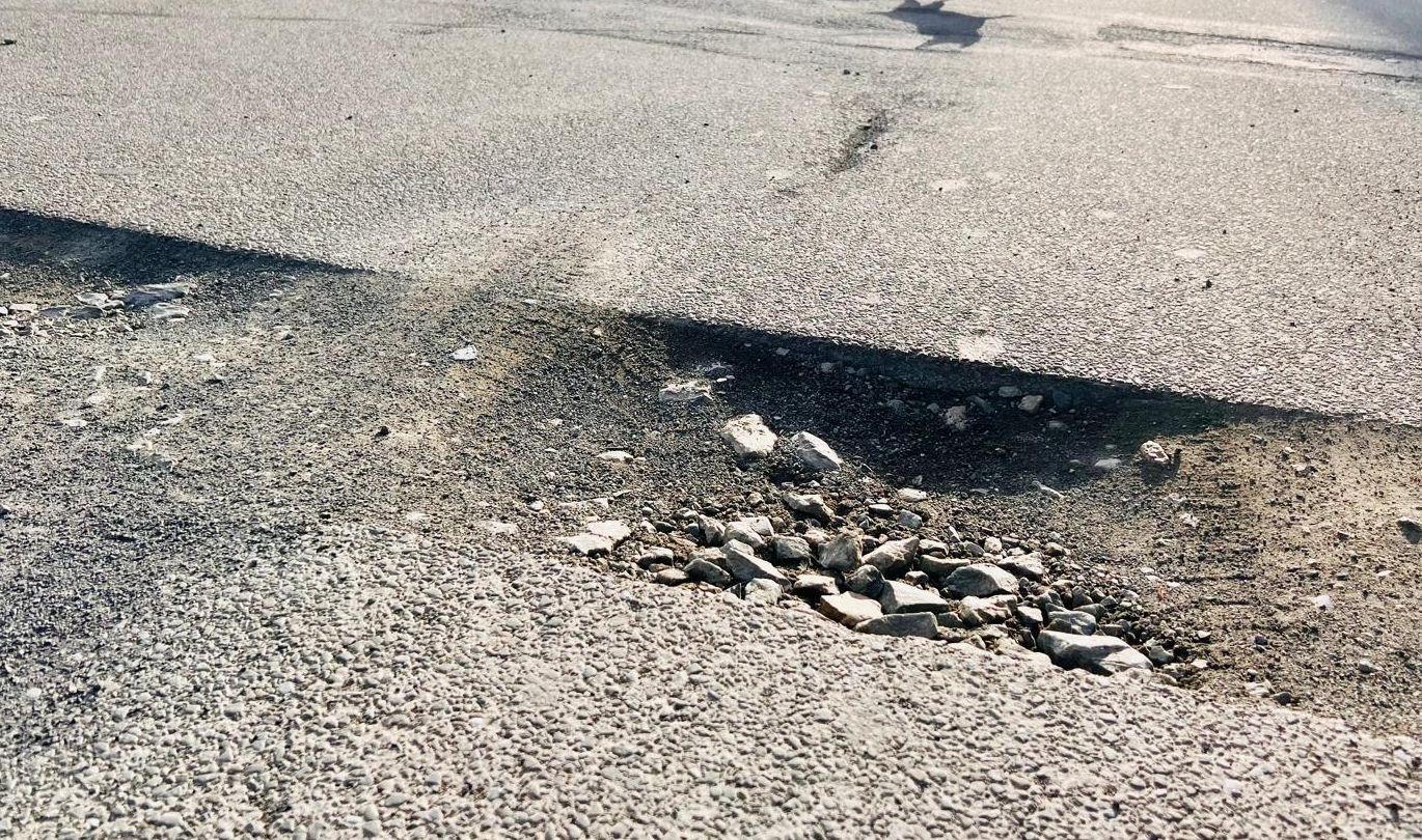 Ein großes Schlagloch im Asphalt der Kantstraße in Halver, vermutlich entstanden durch die Bauarbeiten für den Glasfaserausbau.