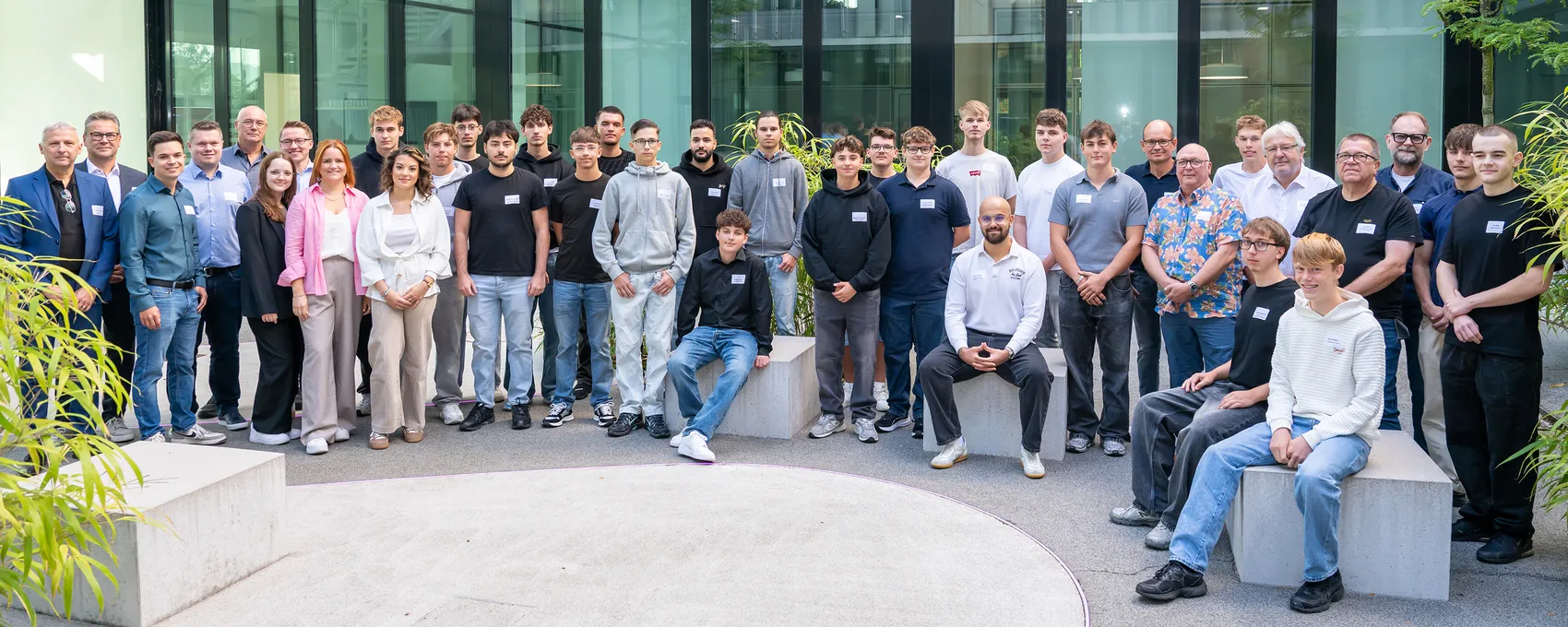 Eine Gruppe von Auszubildenden und Mitarbeitern der Enervie-Gruppe posiert für ein Gruppenfoto vor einem modernen Gebäude.