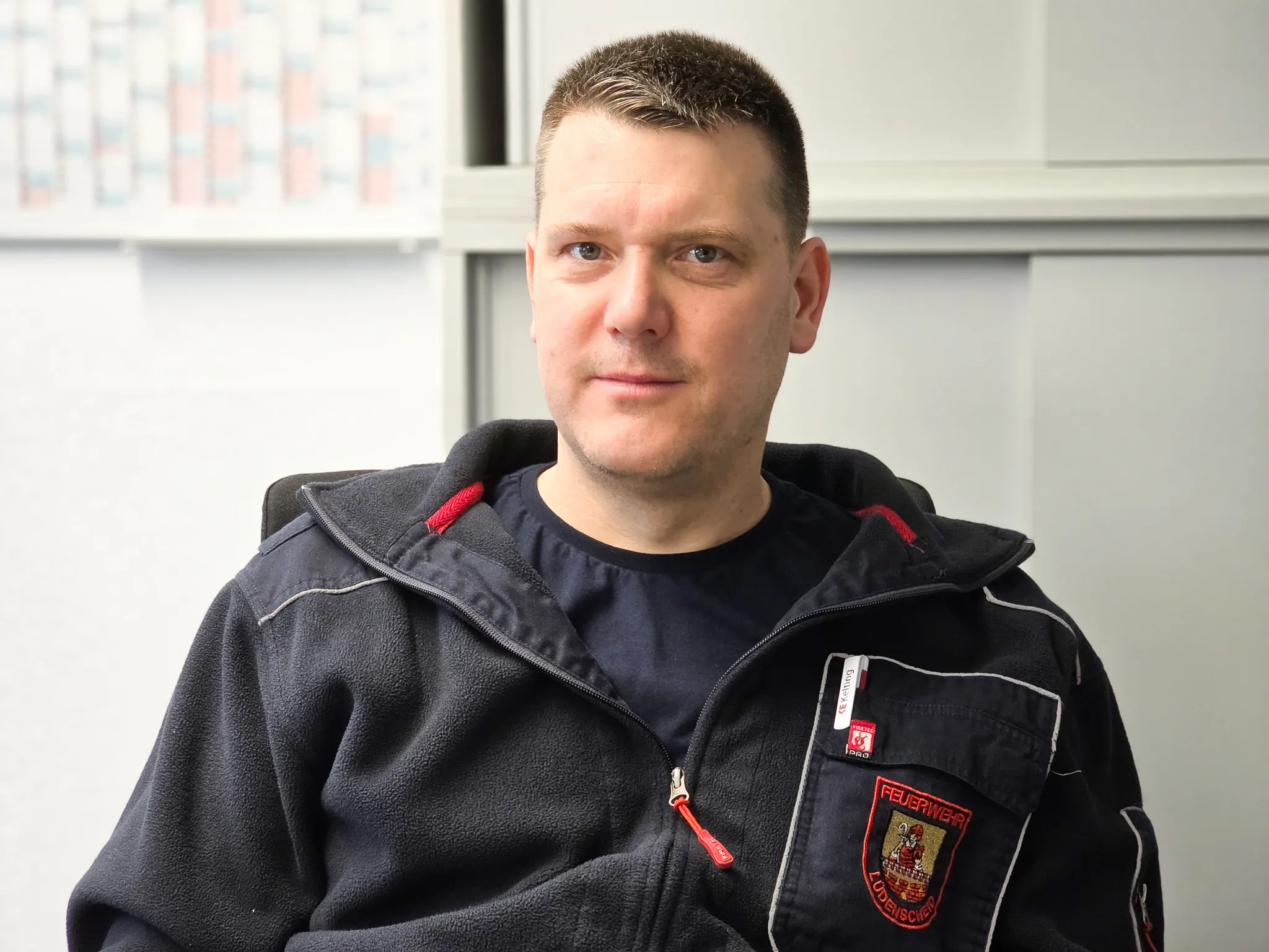 Christian Moll, Brandmeister und Notfallsanitäter der Feuerwehr Lüdenscheid, trägt eine dunkelblaue Uniform mit Abzeichen.