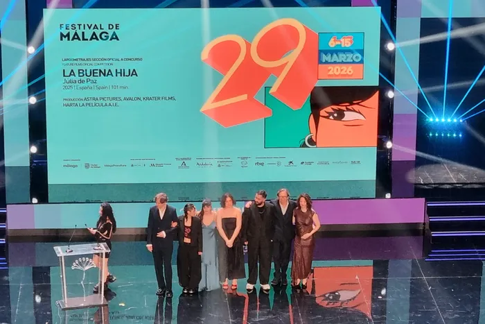 Auf der Bühne des Filmfestivals von Málaga 2026 stehen sieben Personen, darunter Schüler des ESBK, und nehmen eine Auszeichnung entgegen. Im Hintergrund eine Leinwand mit dem Festival-Logo und dem Filmtitel ‚La Buena Hija‘.