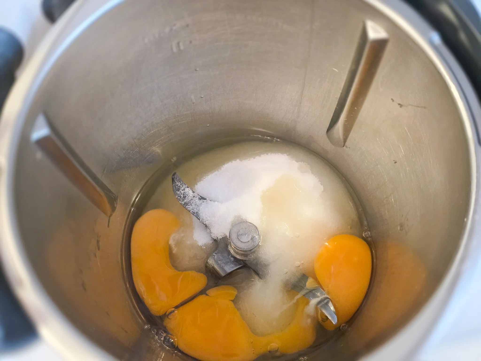 Eier und Zucker in einem Mixerbehälter, bereit zum Verarbeiten für einen Karottenkuchen.