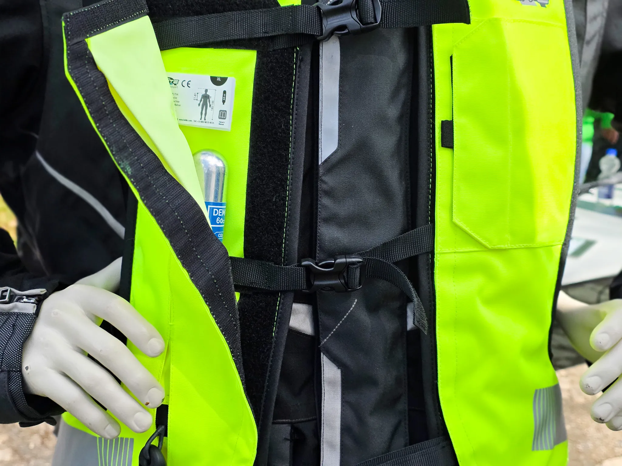 Rückseite einer gelben Schutzweste mit integrierter Vorrichtung für eine CO2-Kartusche und Anweisungen zur Bedienung.