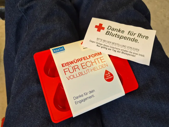 Eiswürfelform in Form eines Bluttropfens und Dankeskarte des Deutschen Roten Kreuzes für Blutspender. Die Karte bewirbt die Eiswürfelform als Geschenk für 