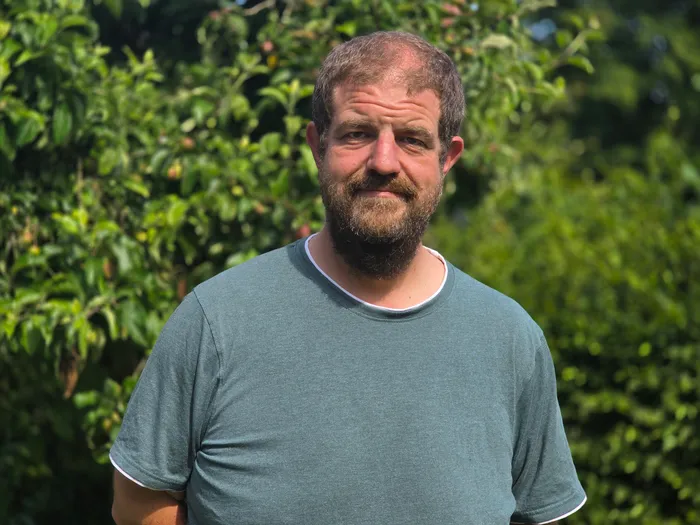 Kristian Filling, Obmann für Öffentlichkeitsarbeit des Hegerings Halver, porträtiert vor grünem Hintergrund. Er hat einen Bart und trägt ein grünes T-Shirt.