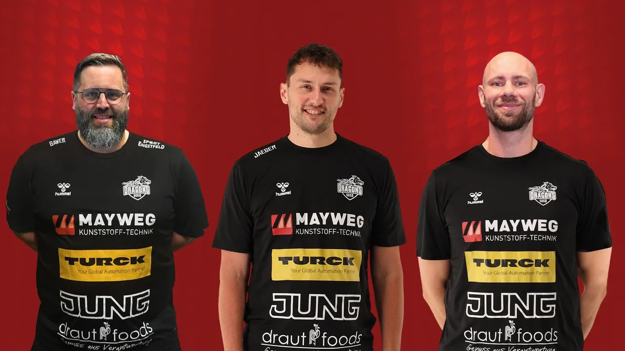 Drei Männer in schwarzen Poloshirts mit Werbelogos stehen nebeneinander. Von links sind es Jens Gawer, Philipp Jaeger und Christoph Brylla, das neue Trainerteam der SGSH Dragons.
