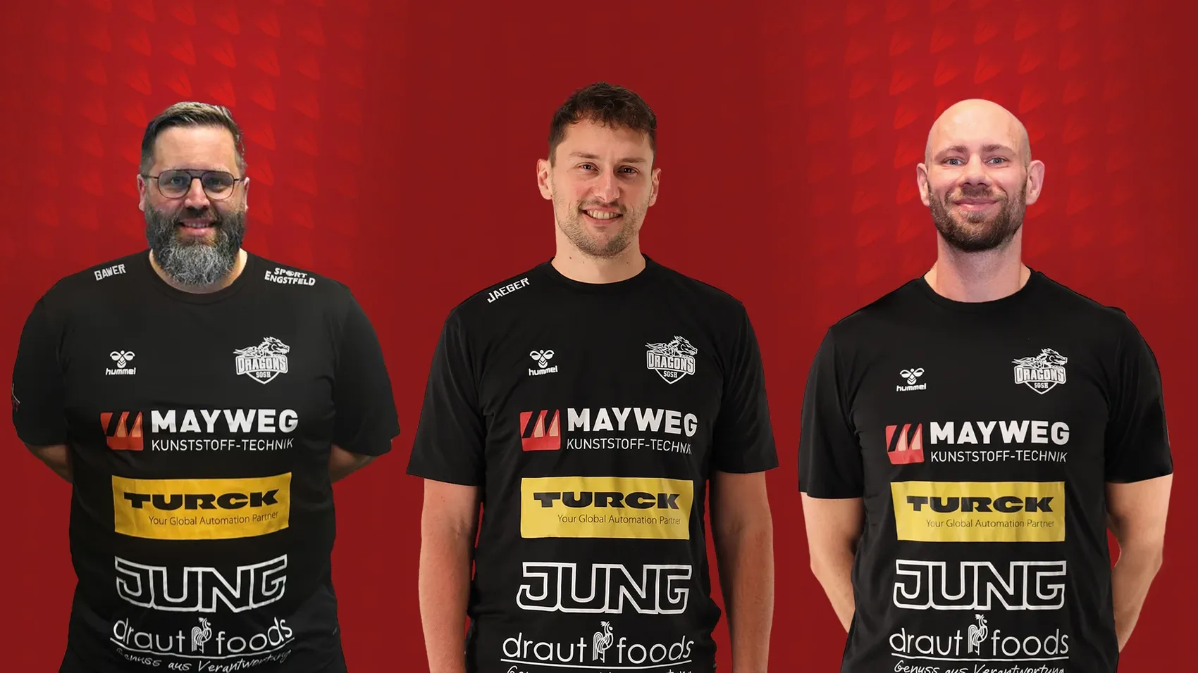 Drei Männer in schwarzen Poloshirts mit Werbelogos stehen nebeneinander. Von links sind es Jens Gawer, Philipp Jaeger und Christoph Brylla, das neue Trainerteam der SGSH Dragons.