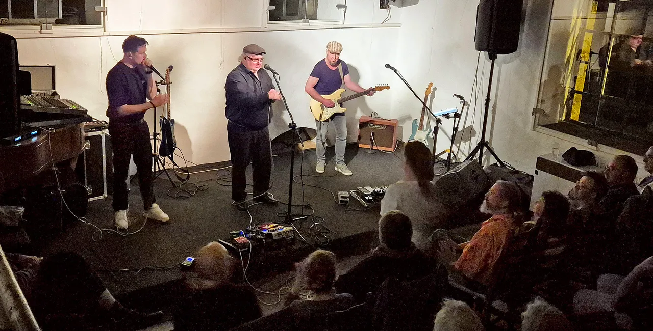 Die Band Chris Kramer & Beatbox ‘n‘ Blues tritt live auf einer Bühne vor einem Publikum auf; ein Musiker spielt E-Gitarre.